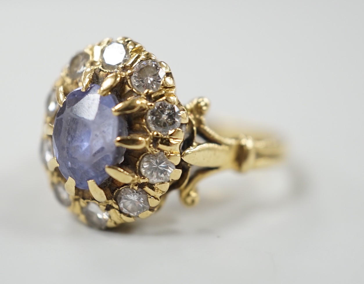 An early to mid 20th century yellow metal, sapphire and diamond set oval cluster dress ring, size